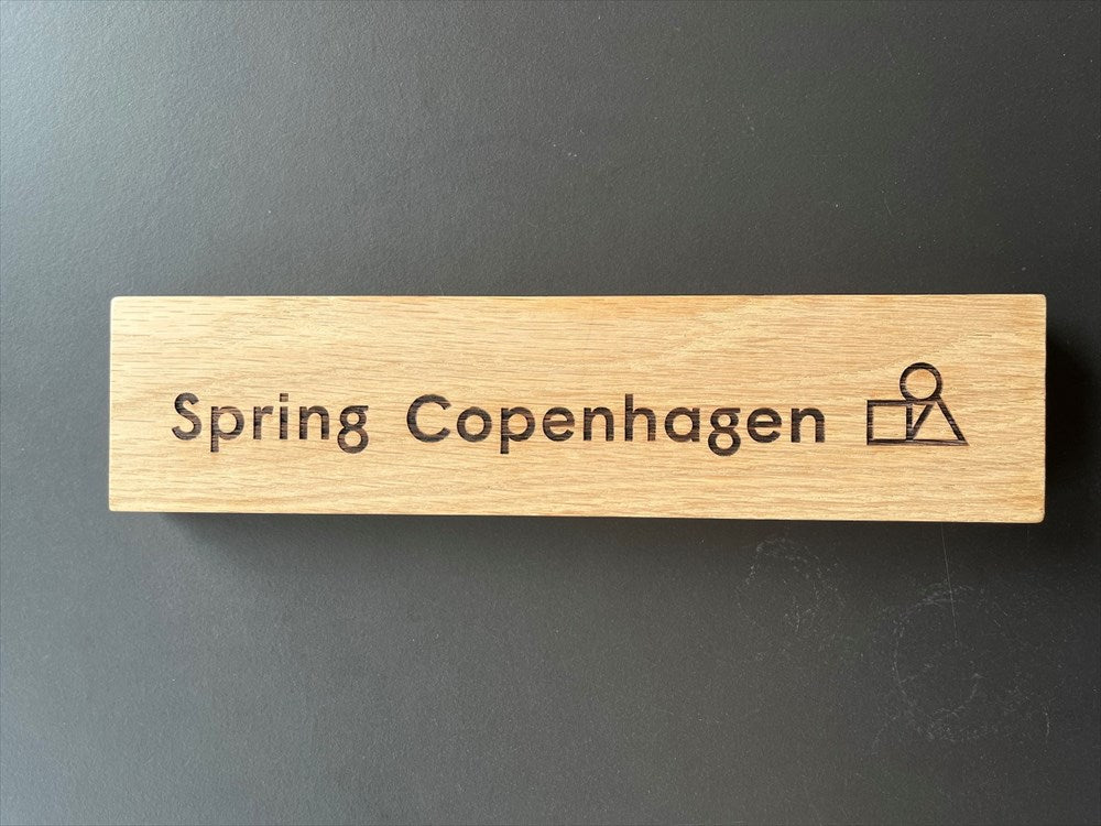 Logotype skylt med motiv "Spring Copenhagen". Material: Ek.