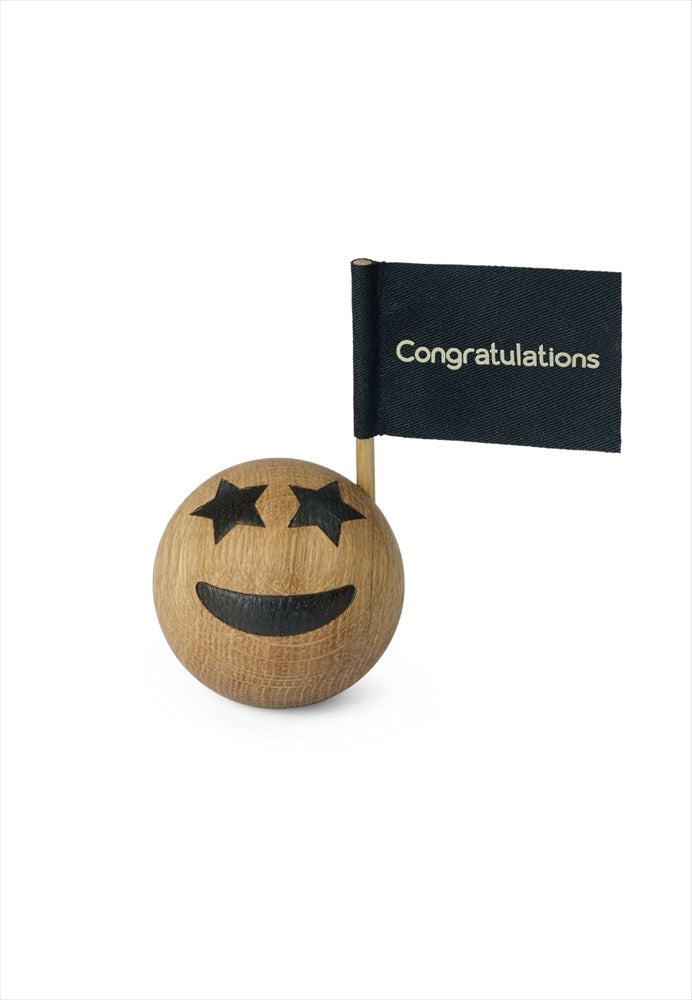 Träfigur. Mått: Ø5,5 cm. Material: FSC ek, textil. Emoji Celebration. Designer: mencke&vagnby